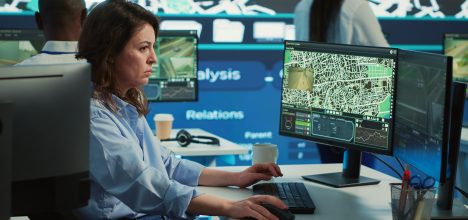 Employee navigating on satellite radar and map to search for routes, helping courier to avoid traffic and successfully deliver orders. Operator in monitoring room using gps coordinates. Camera A.